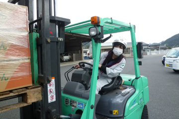 フォークリフトで作業する女性スタッフ